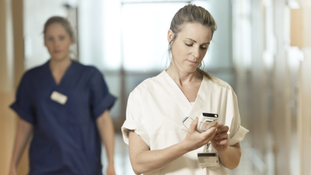 Eine Pflegerin mit einem Smartphone.